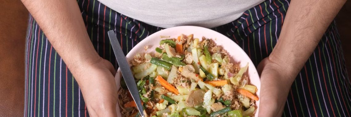 Close-up of a person holding a bowl of mixed vegetables, representing a healthy lifestyle.